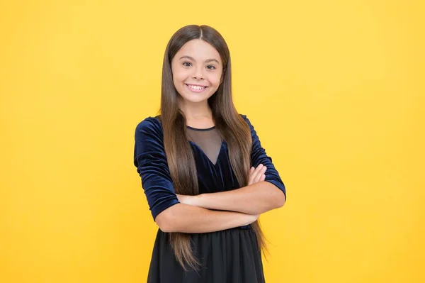 Infanzia felice. allegra ragazza adolescente con i capelli lunghi. esprimere emozioni umane positive. sorridente bambino carino. moda bambino e bellezza. concetto di parrucchiere. adolescente su sfondo giallo — Foto Stock