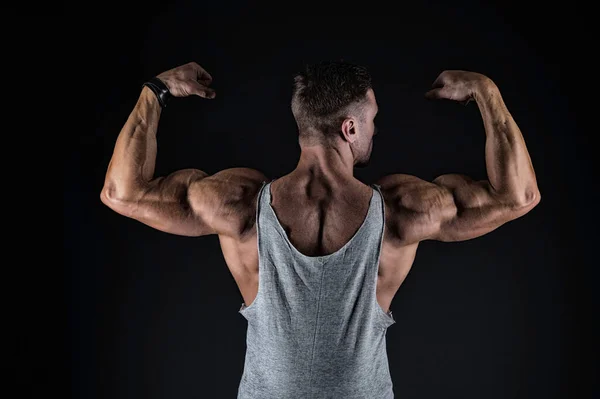 Vamos treinar esse corpo. Fit cara flex braços mostrando bíceps tríceps. Força muscular. Poder e força. Fitness e desporto. Saúde e bem-estar. Construtor de corpo visão traseira fundo preto — Fotografia de Stock