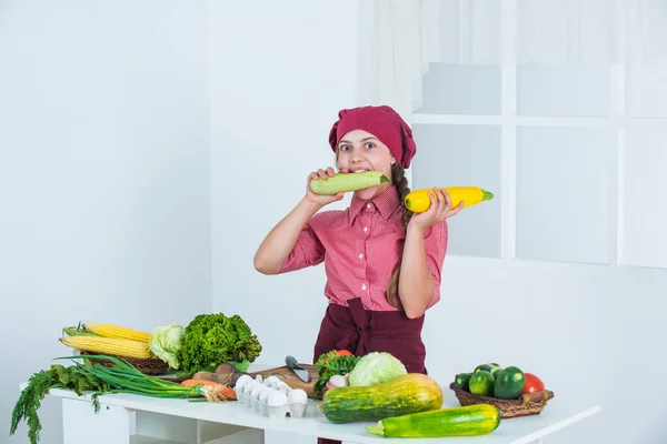 Füttern Sie Ihre Träume. Kind mit Kochmütze verspürt Hunger. Mädchen in der Küche. gesunde biologische Lebensmittel. — Stockfoto