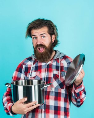 Vay canına. Elinde kızartma tavası olan bir adam... aşçı aşçı bir erkek. Sakallı adam aşçı için hippi damalı gömlek. Mutfak aletleriyle traşsız, vahşi bir adam. Ev eşyaları. Arkadaş canlısı tezgahtar