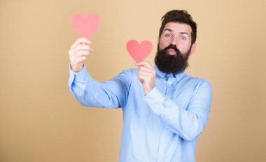 İki kalp aynı anda atıyor. Kırmızı kalp tutan sakallı adam. Küçük kalpli hippi. Kalp şeklinde kartları olan seksi bir sevgililer günü erkeği. Sevgililer günün kutlu olsun. Romantik aşk kutlaması