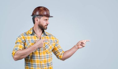 İnşaat kaskı takan yakışıklı bir tamirci ve inşaat alanında kareli tişört. Finegr 'i, fotokopi alanını ve reklamı işaret ediyor.