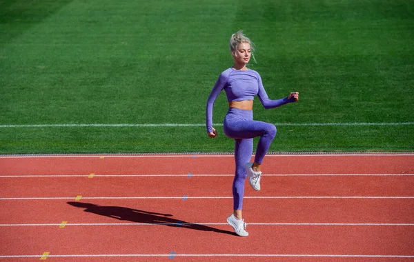 Dame sautant en fitness vêtements de sport. échauffer sur l'arène extérieure. entraînement et entraînement. entraîneure sportive. Entraîneur sportif féminin. mode de vie sain et sportif. santé et énergie. régime alimentaire — Photo