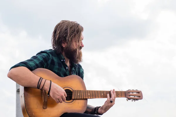 Így kell lazítani. brutális jóképű férfi bajusszal gitározik. érett zenész és énekes. alkalmi stílusú gitáros. modern kinézetű szakállas hipster akusztikus gitárral. zenei koncepció — Stock Fotó