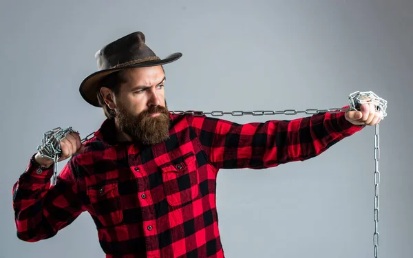 Cowboy uomo con barba e baffi tirare catena d'acciaio, routine al ranch — Foto Stock