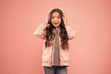 Kulağa harika geliyor. Ses titreşimleri. Müzik ve teknoloji. Ses sesi. Eğlence ve eğlence. Müzik açık. Mutlu çocuk müzik dinlemekten zevk alır. Küçük kız pembe kulaklık takıyor.