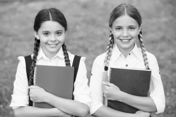 We zijn klaar. Gelukkige meisjes in schooluniform. Lachende tienerstudenten met een copybook. onderwijs op de basisschool. schoolmeisjes die samen vak leren. veel plezier tijdens het studeren — Stockfoto