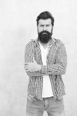 Tıraşsız sakallı, sıradan moda tarzı olan, kollarını çapraz mavi arka planda tutan hippi sakallı adam.