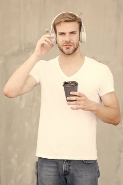 Afiyet olsun. Yakışıklı adam sıcak bardağı dışarıda tutuyor. Genç adam müzik dinlemekten hoşlanıyor. Sabah kahvaltısı ritüeli. Kafein enerjisi. İç ve keyfini çıkar. Kahveden sonra hayatın tadını çıkar