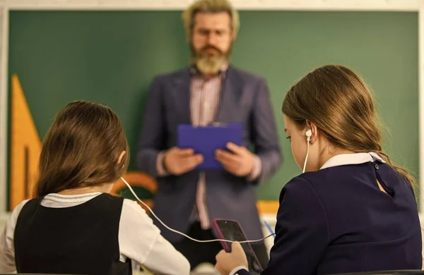 Ebook concept. huiswerk maken schrijven en lezen. kinderen meisjes en leraar man. Basisschool leraar geeft ondersteuning in de klas. Leerling draagt uniform. Studenten die studeren en lezen — Stockfoto