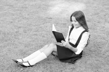 Gurur geleneği. Çok çalışkan bir çocuk. Eğitim ve okuma kavramı. hayal gücünün gelişimi. Şirin kız kitap okuyor. Okul bahçesinde kitabı olan mutlu anaokulu kızı. Okula geri dön.