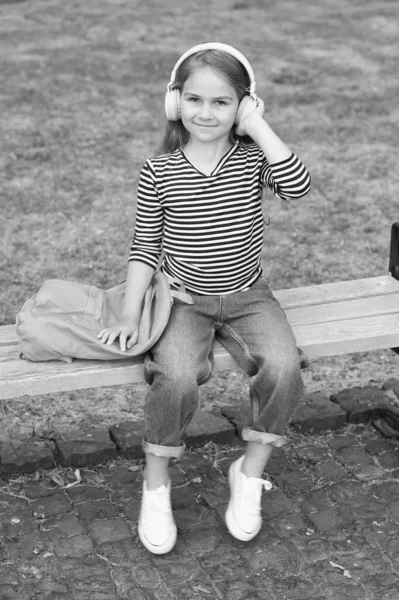 Listen everywhere. Little kid listen to music summer outdoors. Listen technologies. Wireless headphones. Listening comprehension. English school. Musical education. Listening to audio in her own way