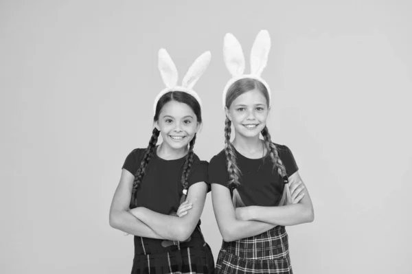 Konijnenteam. Ontspanning en event concept. Voorjaarsvakantie. Kinderen in konijnenoren. Familie en zusterschap. Schoolmeisjes schooluniform met lange konijnenoren. Pasen traditionele games — Stockfoto