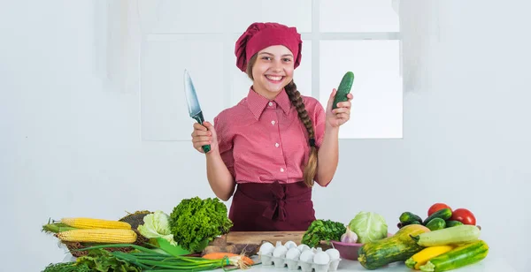 Lachende tiener meisje in chef-kok uniform koken groenten, vitamine — Stockfoto