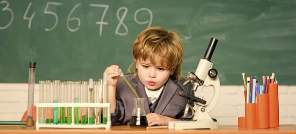 Σχολική εκπαίδευση. Εξερευνήστε βιολογικά μόρια. Μεγαλοφυές μωρό. Τεχνολογία και επιστήμη έννοια. Αγόρι κοντά στο μικροσκόπιο και δοκιμαστικούς σωλήνες στη σχολική τάξη. Το παιδί σπουδάζει βιολογία και χημεία στο σχολείο — Φωτογραφία Αρχείου