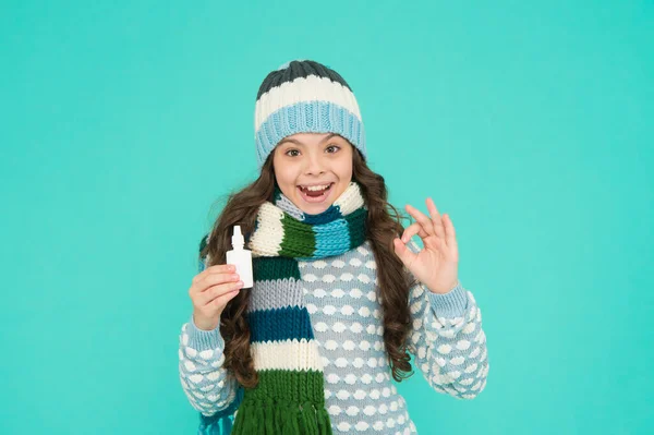 Glad tonåring flicka i stickad tröja och hatt använda nässpray för rinnande näsa behandling, hälsa — Stockfoto