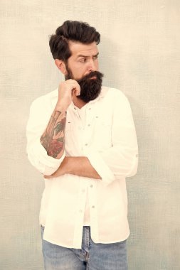 Onun mükemmel tarzı. Hipster adam kot pantolon ve gömlek giyer. Dövmeli kaba sakallı adam. Saç ve sakal bakımı. Erkek bahar modası. Adam berbere tımarlanmış. Güven. Genç sakallı adamın moda portresi.