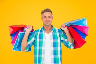 Başarılı erkek alışverişi. Kese kağıdıyla yakışıklı, neşeli bir adam. Kese kağıdında alın. Erkek hediyesini tutar. Bayram indirimi ve özel teklif. Siber pazartesi dükkânda. Müşteri