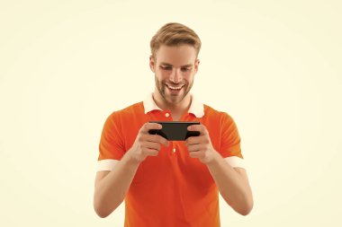 Sakin ol ve oyuna devam et. Mutlu adam beyazda izole bir şekilde gezici oyun oynuyor. Çevrimiçi video oyunu oynuyor. Oyun ve eğlence. Yeni teknoloji. Modern hayat. Akıllı telefon oyunu bağımlılığı