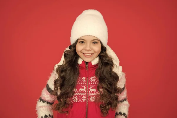 Χειμερινή μόδα. Μικρό κορίτσι με μακριά σγουρά μαλλιά. Ιδέες χειμερινών διακοπών. Χειμερινή δραστηριότητα για παιδιά. Ευτυχισμένη παιδική ηλικία. Παιδί με πλεκτό καπέλο. Τα παιδιά έχουν την τάση να κρυώνουν περισσότερο από τους ενήλικες. Μεγάλη χαρακτηριστικά και το σχεδιασμό — Φωτογραφία Αρχείου