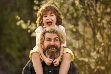 Doğada yaşayan küçük bir çocuk ve baba. Hippi ve küçük oğlu. Birlikte bahçeyi keşfediyoruz. Mutluluk kavramı. Basit mutluluk. Mutlu bir aile. Bahar yürüyüşü. Babalık mutluluğu. Babalar Günü