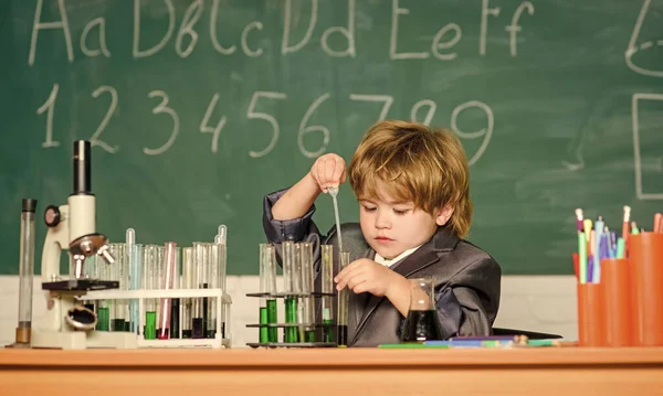 Fascinerande ämne. Kunskapsdagen. Grabben studerar biologi kemi. Grundläggande kunskaper i grundskolan. Ett pedagogiskt experiment. Pojkmikroskop och provrör i klassrummet. Kunskapsbegreppet — Stockfoto