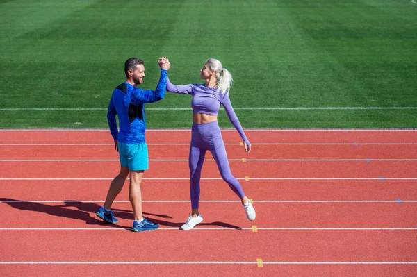 Casal esporte comemorar a vitória da equipe. parceiros de fitness. homem atlético e mulher sexy competem na luta armada. Treinador masculino e feminino no estádio pista de corrida arena. estilo de vida saudável — Fotografia de Stock