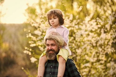 Seni görmek ne güzel. Bahar zamanı birlikte. Küçük çocuk babasıyla mutlu. Aile eğleniyor. Parkta çiçek açıyor. çocukluk ve ebeveynlik mutluluğu. Sevgi ve destek. Baba ve oğul çiçek açan ağaçta