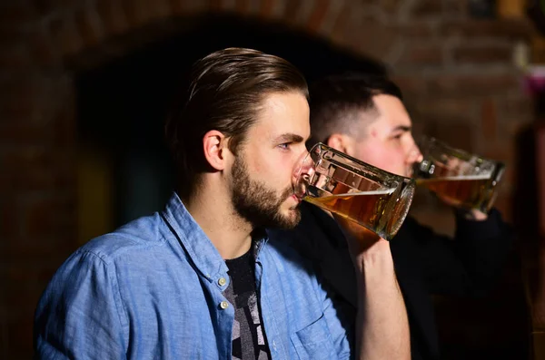 Caras no balcão de madeira segurar copos de cerveja leve. — Fotografia de Stock