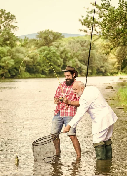 Ganhar dinheiro com o conceito de ideia. passatempo de homem de negócios. pesca da reforma. pescadores felizes. Bom lucro. Voar aventuras de pesca. pai aposentado e filho barbudo maduro. amigos homens com vara de pesca e rede — Fotografia de Stock