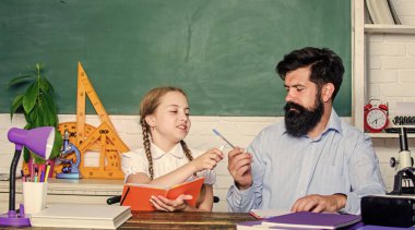 Eğitim çocuk gelişimi. Okula dönüyorum. Sınıfında küçük bir kız olan sakallı bir öğretmen. Bilgi günü. Evde eğitim. Kızım babasıyla ders çalışıyor. Öğretmenler günü. Çocukluk anıları