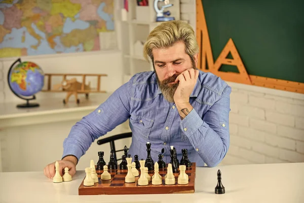 thinking of next move. bearded man training for chess competition. chess figures on wooden board. Focused school teacher. thinking of attacking and capturing opponent chess pieces