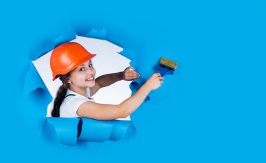 İnan bana, ben bir uzmanım. Çocuk inşaat alanında kask takıyor. Fırça boyama aletli genç kız ressam. Çocuk tamir işiyle uğraşıyor. Atölyede yenileme konsepti. meşgul profesyonel marangoz