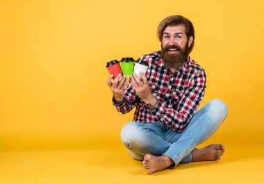 Kafe reklamı. Kahve molası veriyor. Yakışıklı, olgun bir adam içki içiyor. Bir fincan kahve ya da çay al. Yaşam tarzı konsepti. Bir fincan kahveli hippi adam. Kopyalama alanı