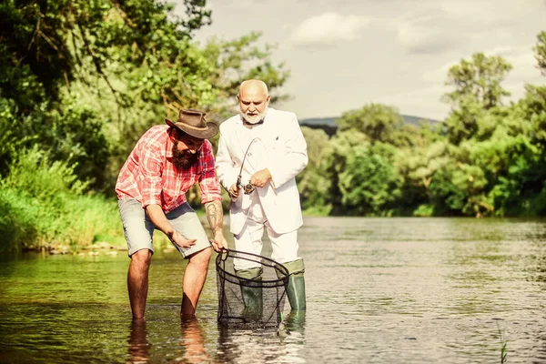 Simplement être dans le coin. Deux amis mâles pêchant ensemble. père à la retraite et fils barbu mature. heureux pêcheurs amitié. mouche passe-temps de poisson de l'homme d'affaires. pêche à la retraite. Concept de capture et de pêche — Photo