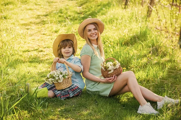 Best day ever. mothers day. small boy love mom. summer holiday vacation. mother and kid relax in park. picnic on green grass. spring bloom in basket. mother and son in straw hat. happy family day