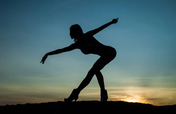 Μπαλαρίνα. γυναικεία σιλουέτα στο φόντο του ουρανού. την αίσθηση της ελευθερίας. θηλυκή σιλουέτα στο ηλιοβασίλεμα. Γυναίκα χορεύει το ξημέρωμα. σκοτεινή φιγούρα χορευτή. Χορεύοντας το βράδυ. σκιά και σκιά — Φωτογραφία Αρχείου
