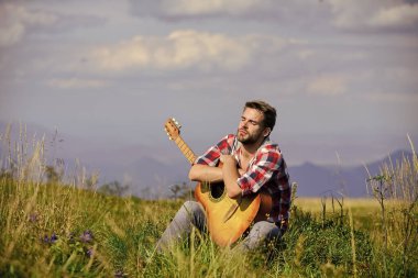 Doğayla bütünleşti. İlham arayan bir müzisyen. Hayalperest gezgin. Huzurlu bir ruh hali. Gitarlı adam doğayı düşünüyor. Seyahat tutkusu konsepti. İlham verici bir doğa. Yaz tatili. İlham perisi ararken