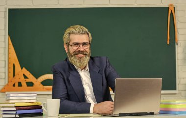 Öğretmenlik mesleği. Mutlu okul öğretmeni. Sakallı adam sınıfta ders veriyor. Özel ders. Öğretmek ve öğrenmek. Pedagoji. Pedagojik teknikler. Okul ve eğitim