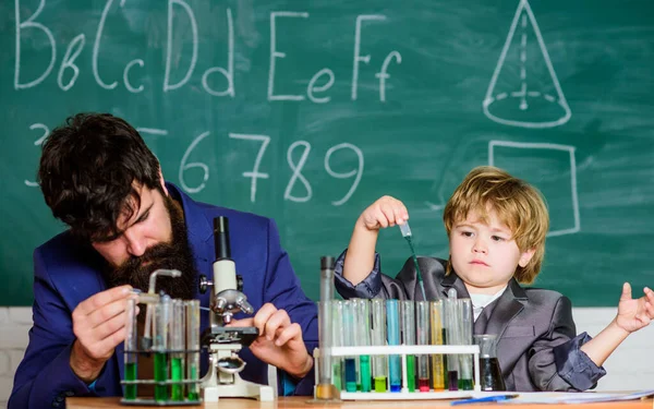 Jag älskar studier i skolan. Studera kemi. Att studera är intressant. Studera i pedagogisk verksamhet genom erfarenhet. Kemisk uppfinning. Skolans laboratorium. Lärare och elevpojke i kemiskt laboratorium — Stockfoto