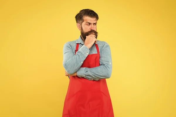 Chef prêt à cuisiner. serveur brutal ou barista. Barbier dans un tablier à longue barbe. bel homme confiant maître. Entrepreneur dans son look moderne. chef barbu ou serveur portant tablier rouge — Photo