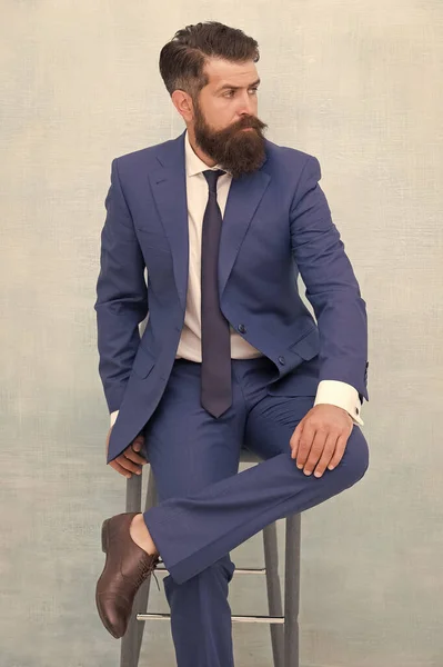 Elegante, mas moderno. O homem de negócios senta-se na cadeira. Elegante empresário ou empresário. O homem de negócios usa fato formal. Homem de negócios brutal em roupa formal. Moda formal e estilo. Código de vestuário comercial — Fotografia de Stock