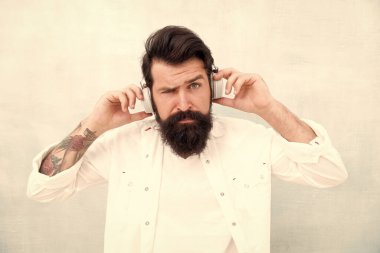 Açık havada müzik dinlemek. Favori şarkılar ve şarkılar. Yürüyüş için ritim. Hippi ayarlanabilir beyaz kulaklık takıyor. Sakallı adam müzik sever. Kablosuz teknolojili kulaklıklar. İlham verici müzik konsepti