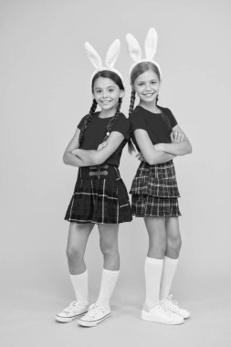 Mutlu Paskalyalar. Güzel tavşancık. Eğlence ve olay konsepti. Bahar tatili. Tavşan kulaklı çocuklar. Aile ve kardeşlik. Küçük okul kızları uzun tavşan kulaklı aynı okul üniforması