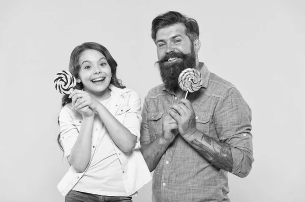 Gelukkig familie vader en dochter eten lolly gele achtergrond, geluk ziet eruit als dit concept — Stockfoto