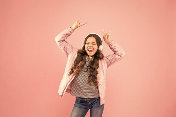 Love dancing too much. Karaoke party fun. Fun and entertainment. Joining in a song. Small girl with sad look pink background. Little child hear stereo sound. Enjoying song playing in headphones