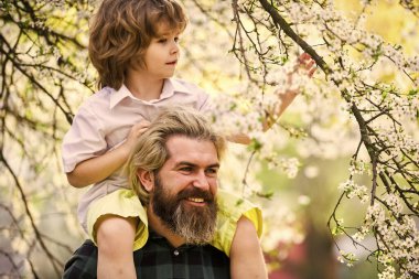 Babalar Günü. Baba ve oğul. Gelmiş geçmiş en iyi baba. Çocuk babasıyla eğleniyor. Mutlu bir aile. Doğada yaşayan küçük bir çocuk ve baba. İlkbahar. Hippi bebeği sırtında taşıyor. Sakallı zalim adam İyi baba