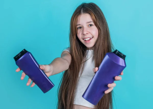Menina alegre com cabelo liso longo segurar condicionador xampu ou garrafa de gel, higiene — Fotografia de Stock