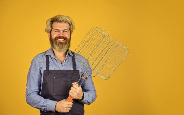 Yaz pikniği. Hippi, BBC ekipmanlarını tanıtmak için sakal boyamış. Sağlıklı yemek yapmak. Barbekü ızgarası önlüklü adam. Kızarmış et için aletler. Mutfak aletleri. Mutfak konsepti. Şef bbq yemeği pişiriyor.