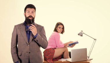 Seksi ofis çalışanı. Seksi özel sekreter. Arzu dolu. Ofis kolektif konsepti. Sakallı patron dizüstü bilgisayarda çalışan seksi bir kızın önünde duruyor. Cinsel provokasyon. Ofis yöneticisi veya sekreteri